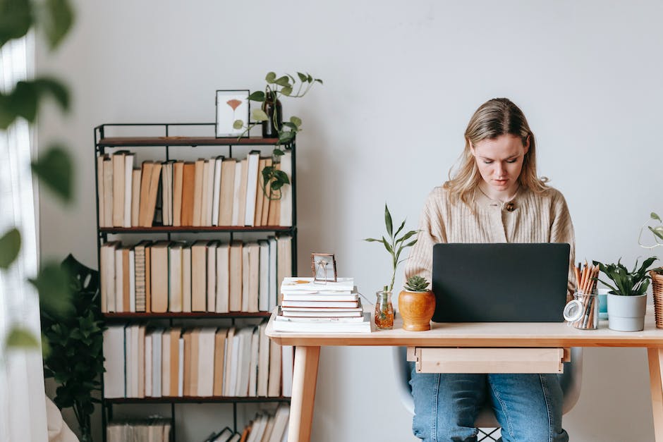 An image depicting a person stressed out with piles of work surrounding them, symbolizing work-life imbalance and its negative impacts.